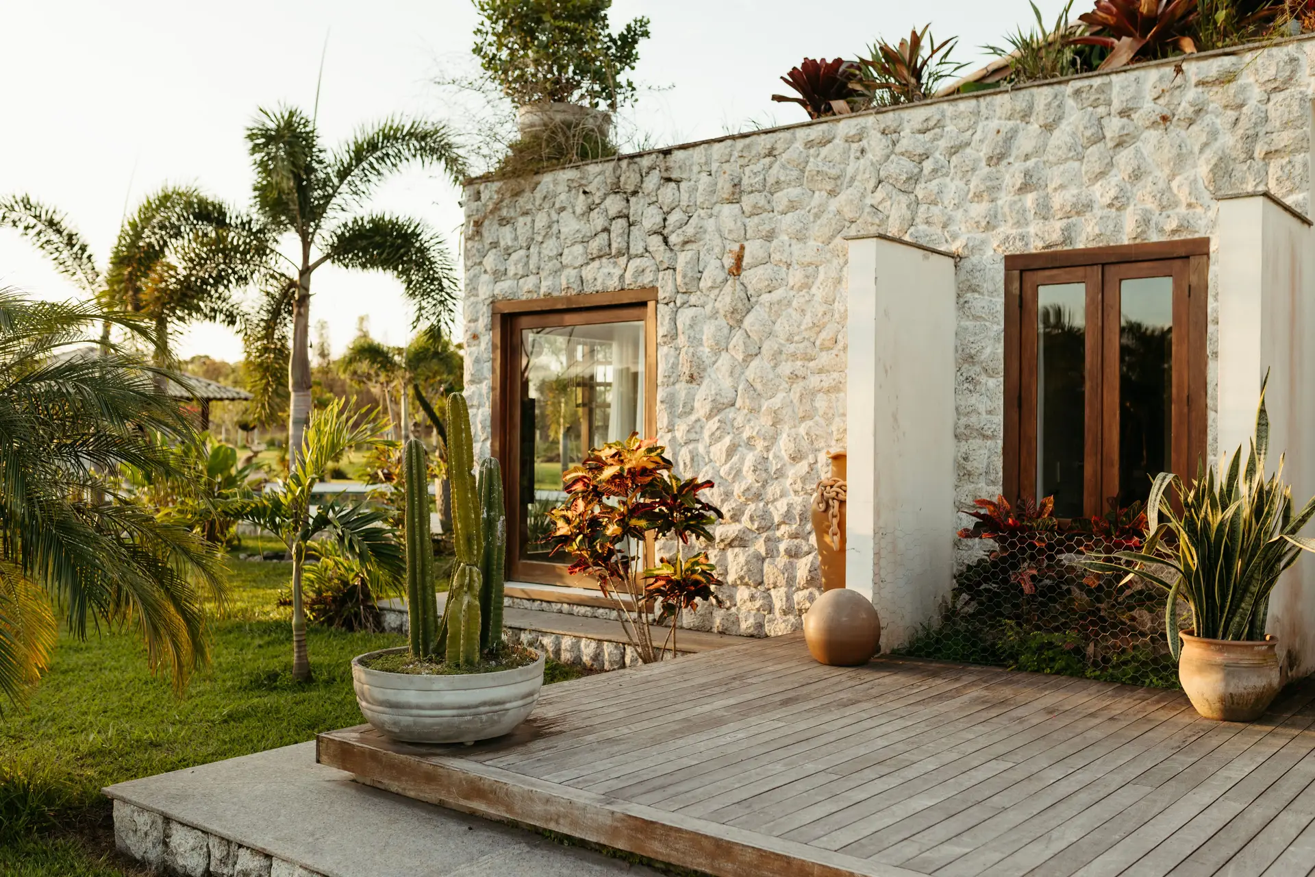 Architektonischer Gartenraum mit mediterran anmutenden Natursteinmauern und Pflanzen