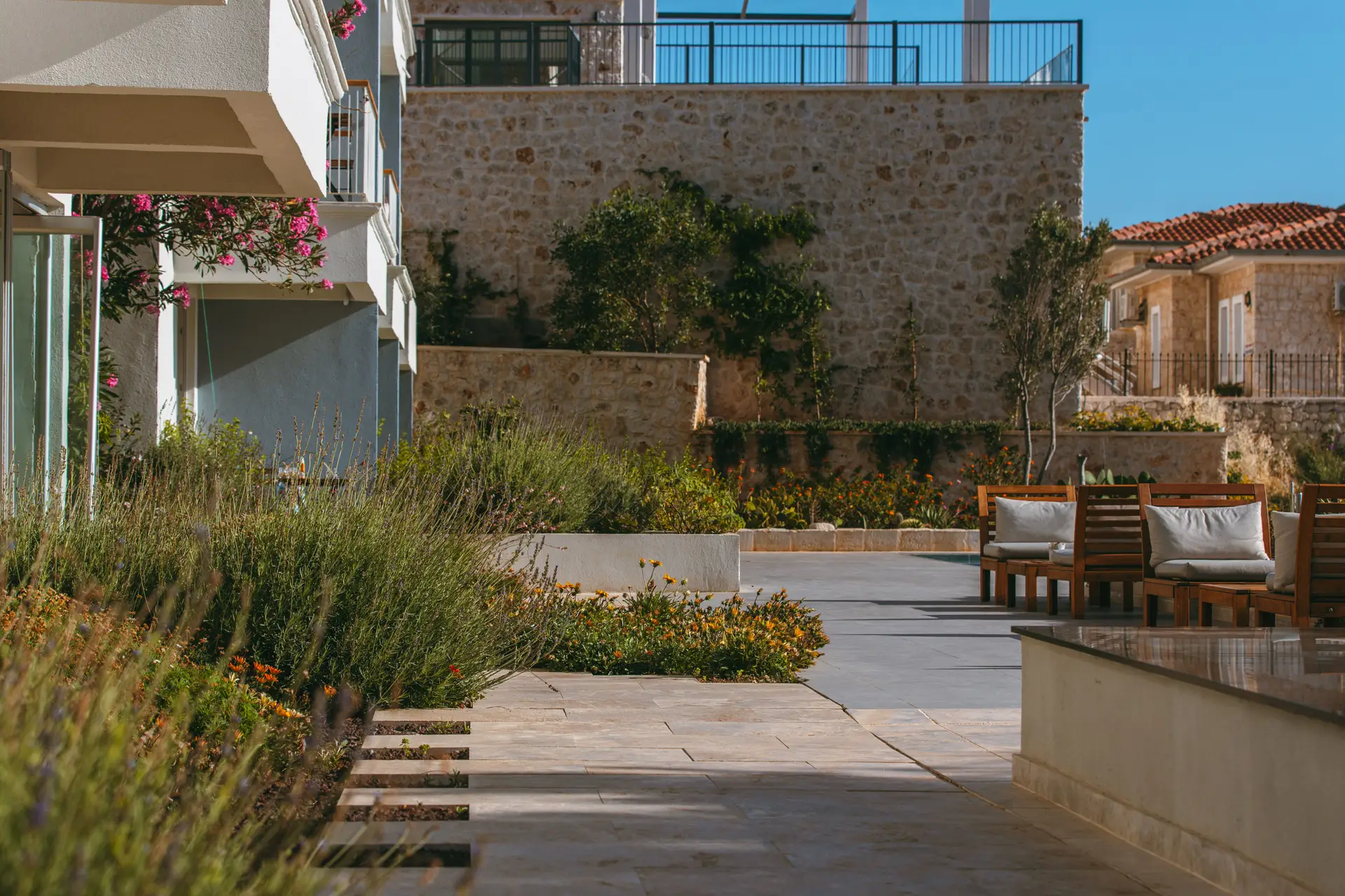 Mediterraner Gartenraum mit Trockenmauerwerk und duftenden Kräuterpflanzungen