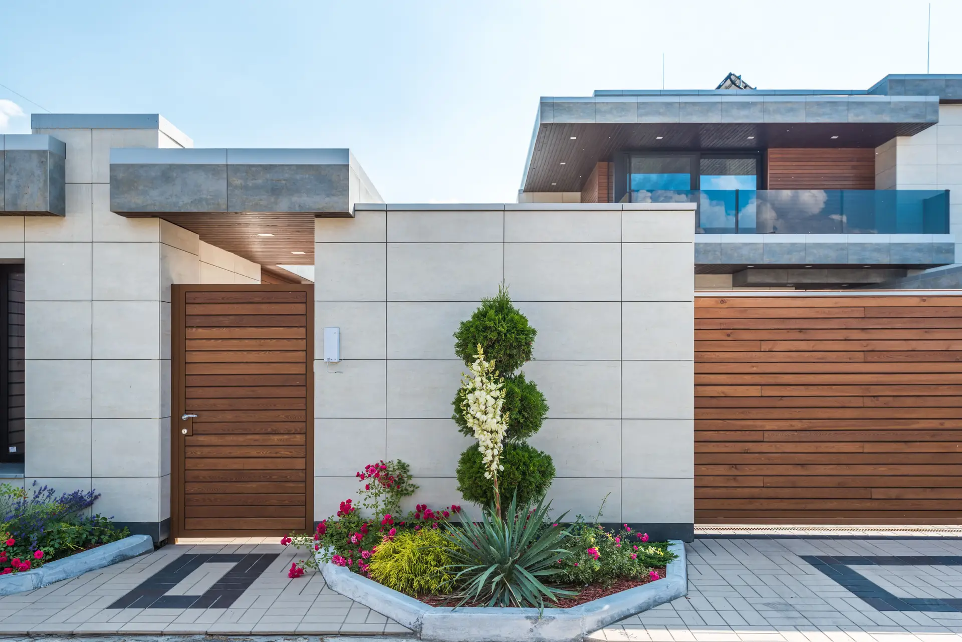 Architektonischer Hauseingang mit klaren Achsen, Holzlamellen und Ziergräsern